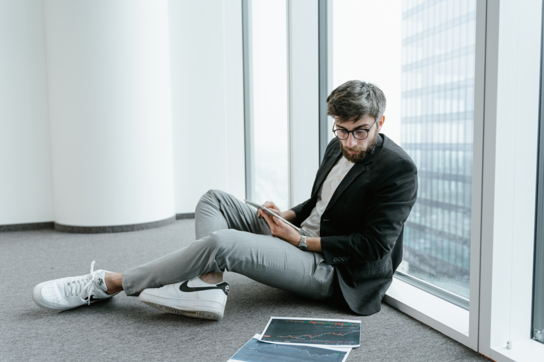 a man sits in the office and looks at the notes with the Bitcoin exchange rate