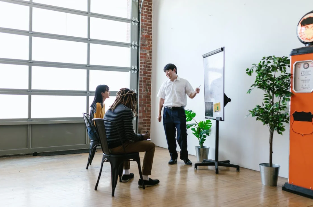 a group of people in the office, a man stands near the board and talks about cryptocurrency