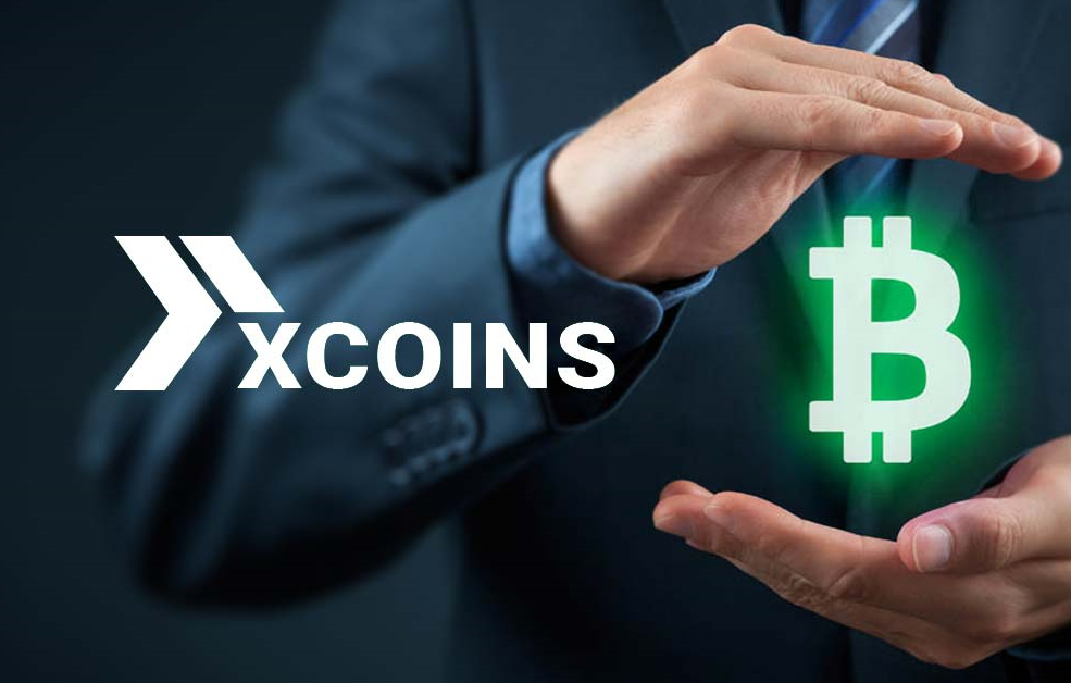 man in a suit holds a Bitcoin icon, on the left is a company logo xCoins